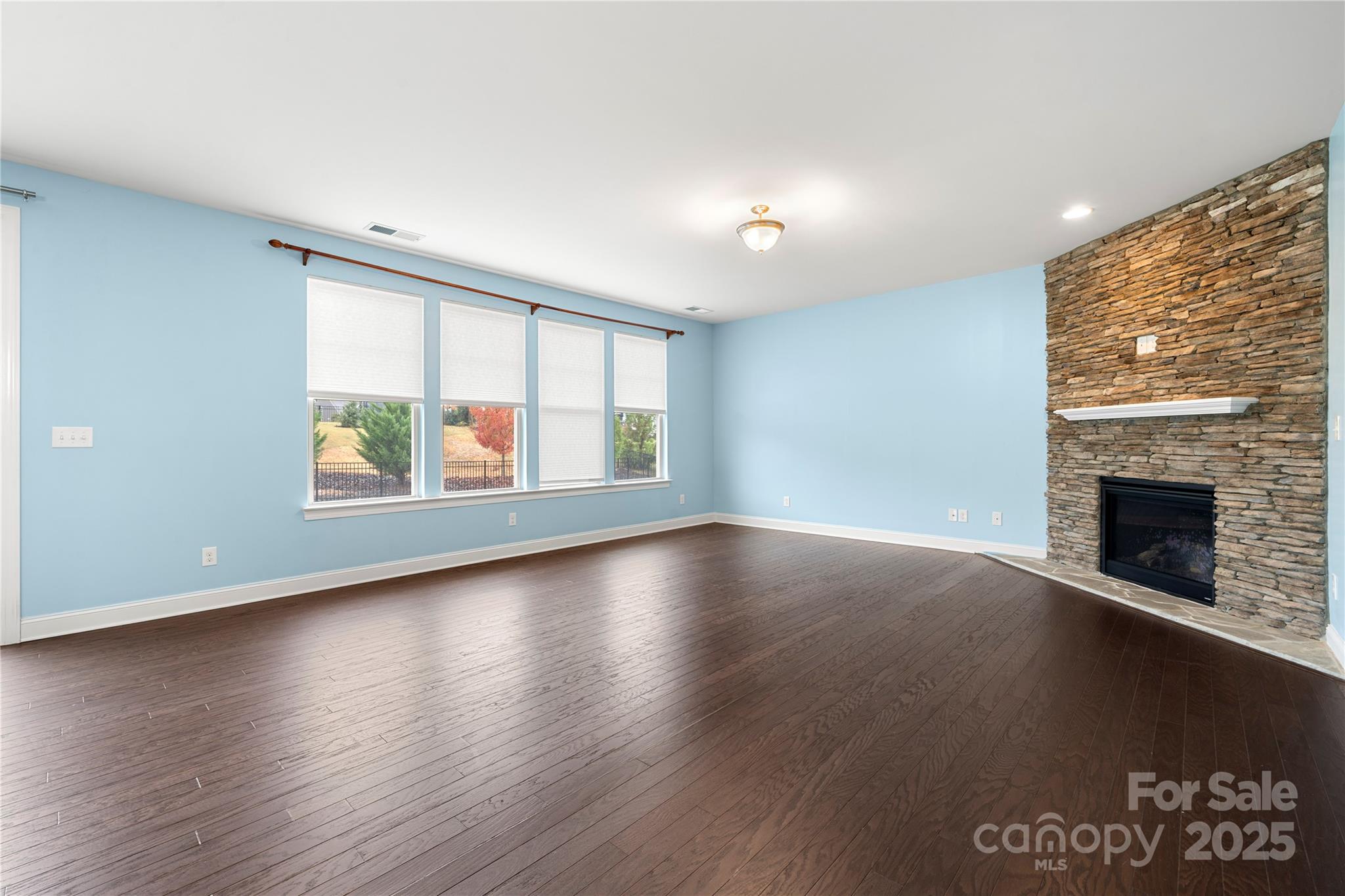 206 Houston Blair Road Matthews, NC 28104 - Photo 12 of 44 an empty room with wooden floor fireplace and windows