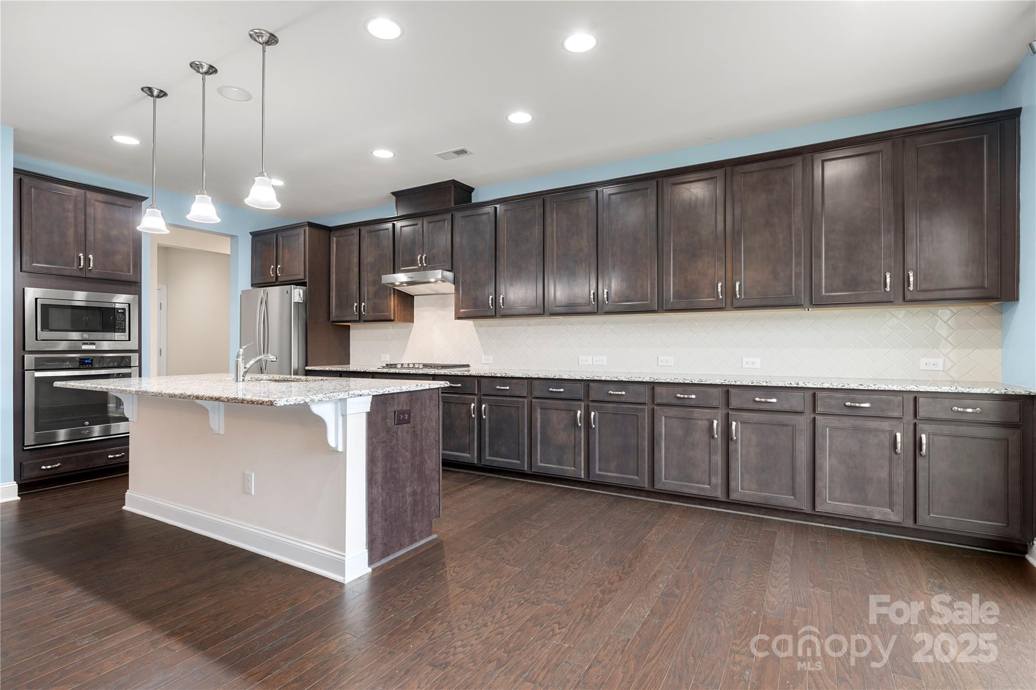 206 Houston Blair Road Matthews, NC 28104 - Photo 18 of 44 a kitchen with kitchen island wooden cabinets and refrigerator