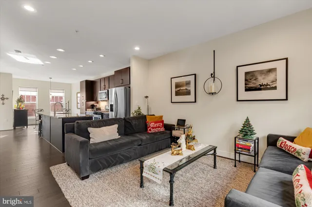 a living room with furniture kitchen view and a potted plant