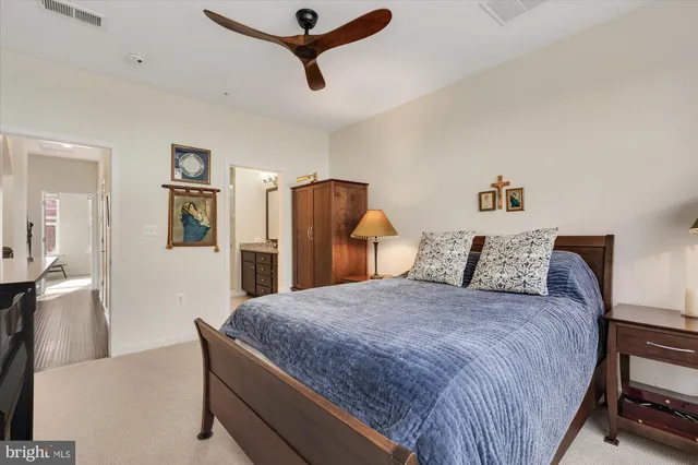 a large bed in a white room with a tv