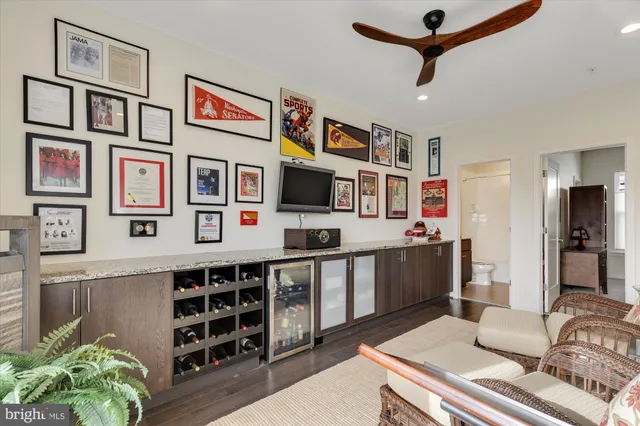 a living room with stainless steel appliances furniture a rug and a window