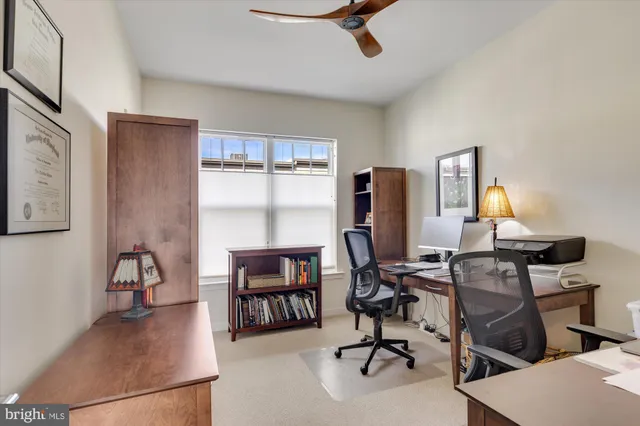a view of a workspace with furniture and a window