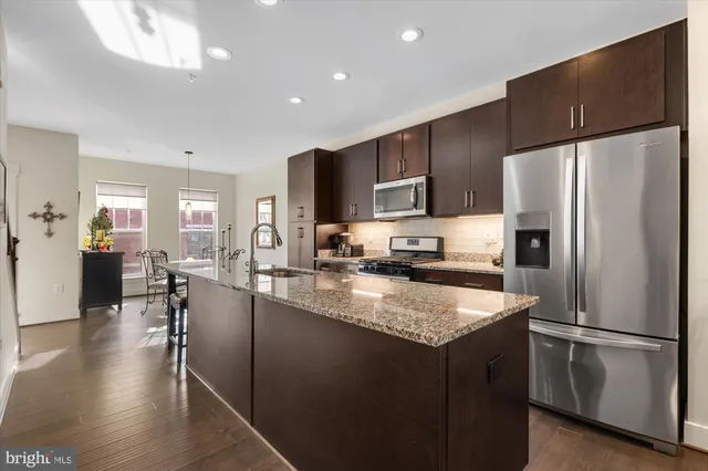 a kitchen with stainless steel appliances granite countertop a refrigerator stove microwave and sink