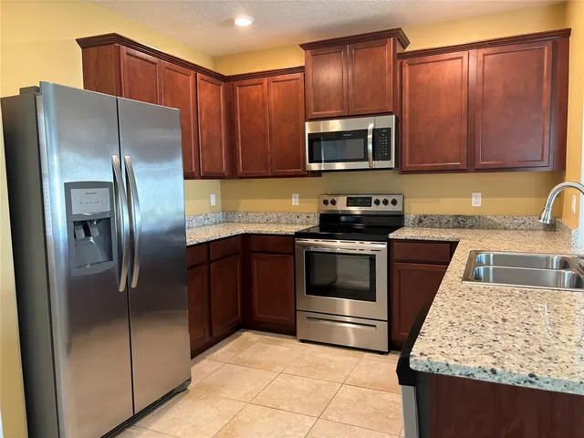 a kitchen with granite countertop stainless steel appliances and wooden cabinets