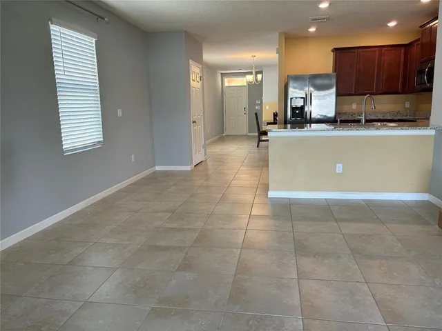 a kitchen with kitchen island granite countertop a sink a counter top space appliances and cabinets