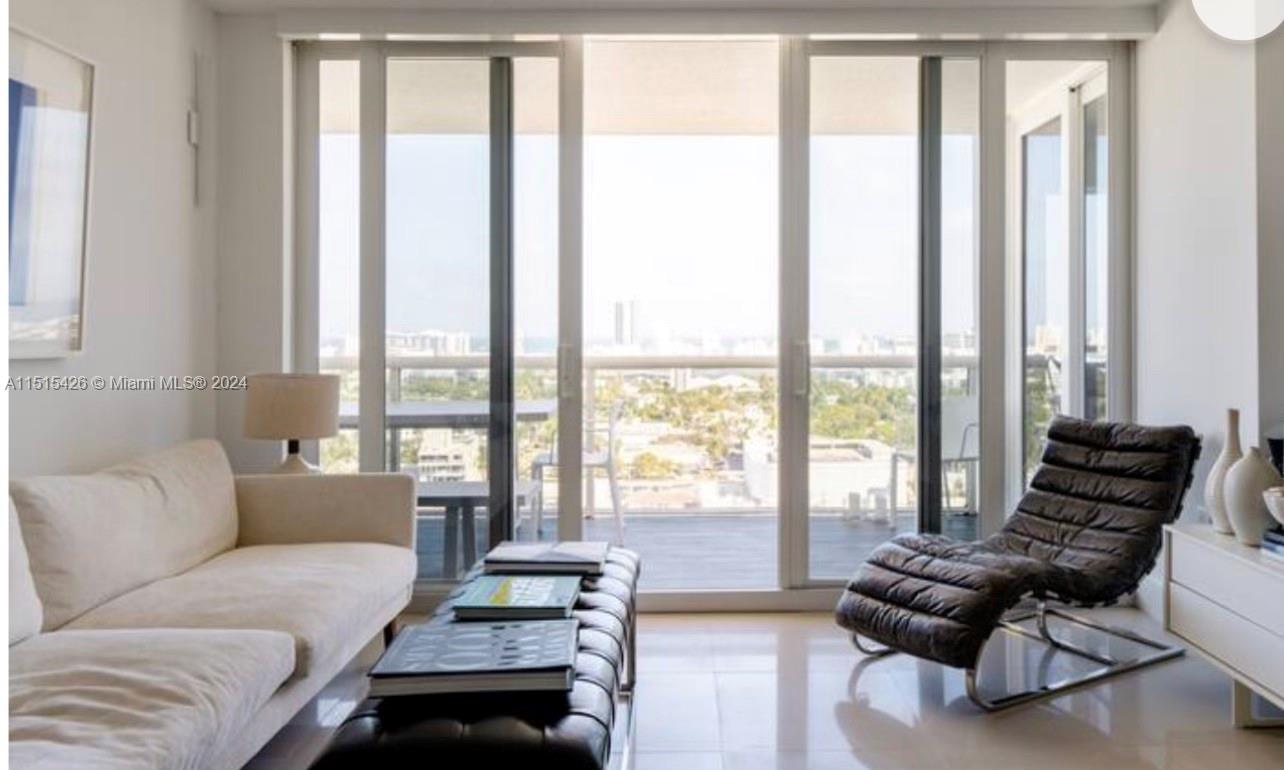 a living room with furniture and floor to ceiling windows