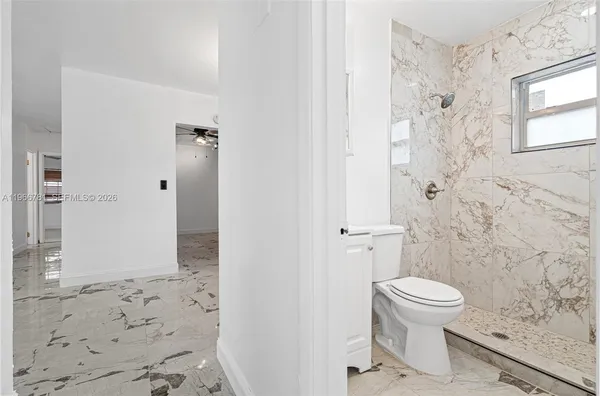 a bathroom with a toilet and a shower