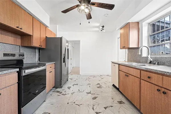 a kitchen with stainless steel appliances granite countertop a sink stove and refrigerator