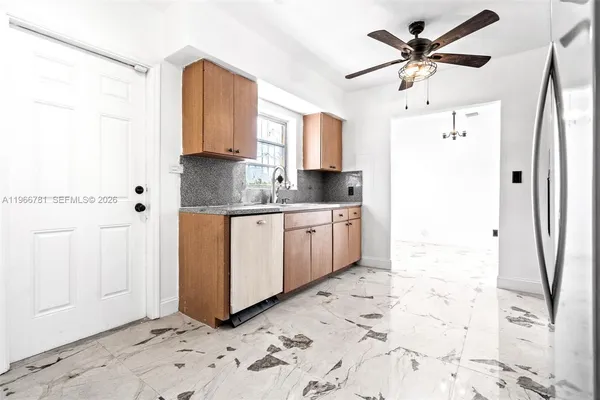 a view of a kitchen with a sink a refrigerator and cabinets