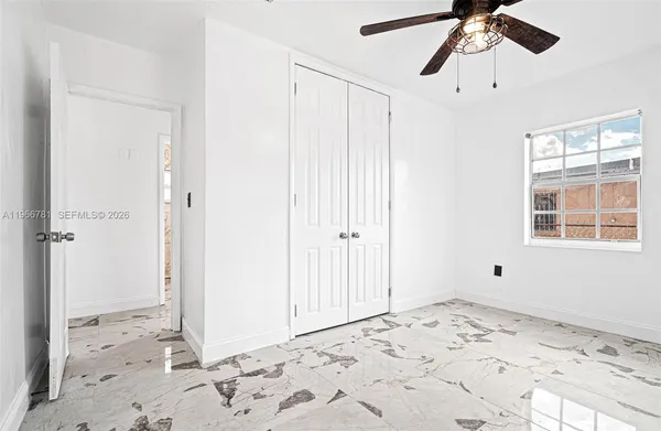 a view of a bedroom with a bed and wooden floor