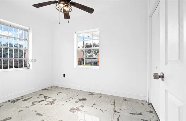 a view of a bedroom with a bed and a window