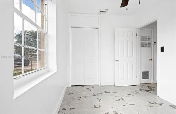 a view of a small space with wooden floor and a window