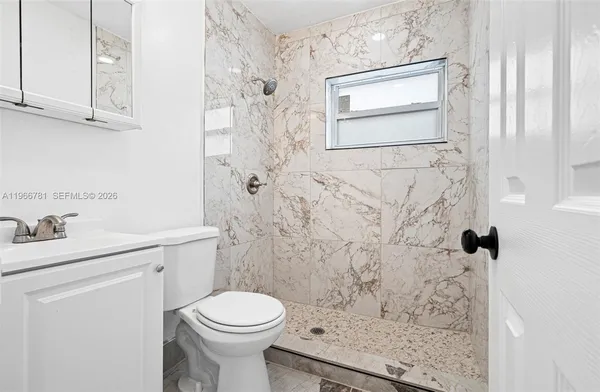 a bathroom with a sink toilet and shower