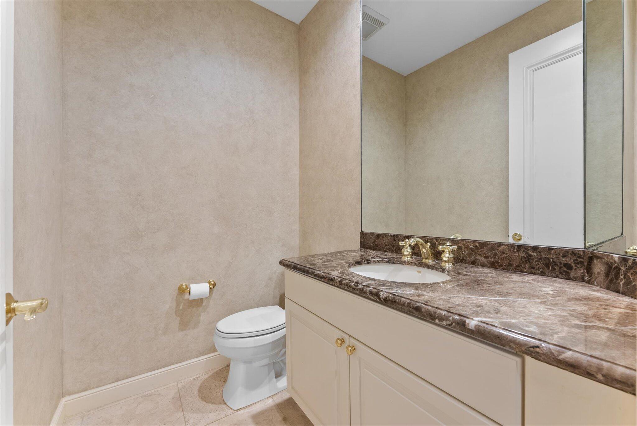 7081 Mallorca Crescent Boca Raton, FL 33433 - Photo 7 of 26 a bathroom with a granite countertop sink a toilet and a mirror
