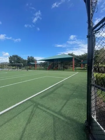 a view of a tennis ground with large trees