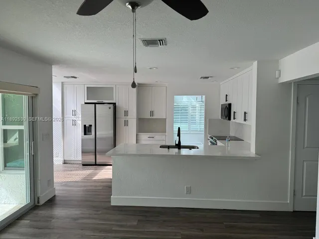 a view of a kitchen with stainless steel appliances granite countertop a refrigerator and a sink