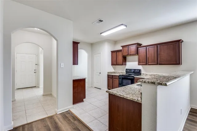 a kitchen with stainless steel appliances granite countertop a stove refrigerator sink and microwave