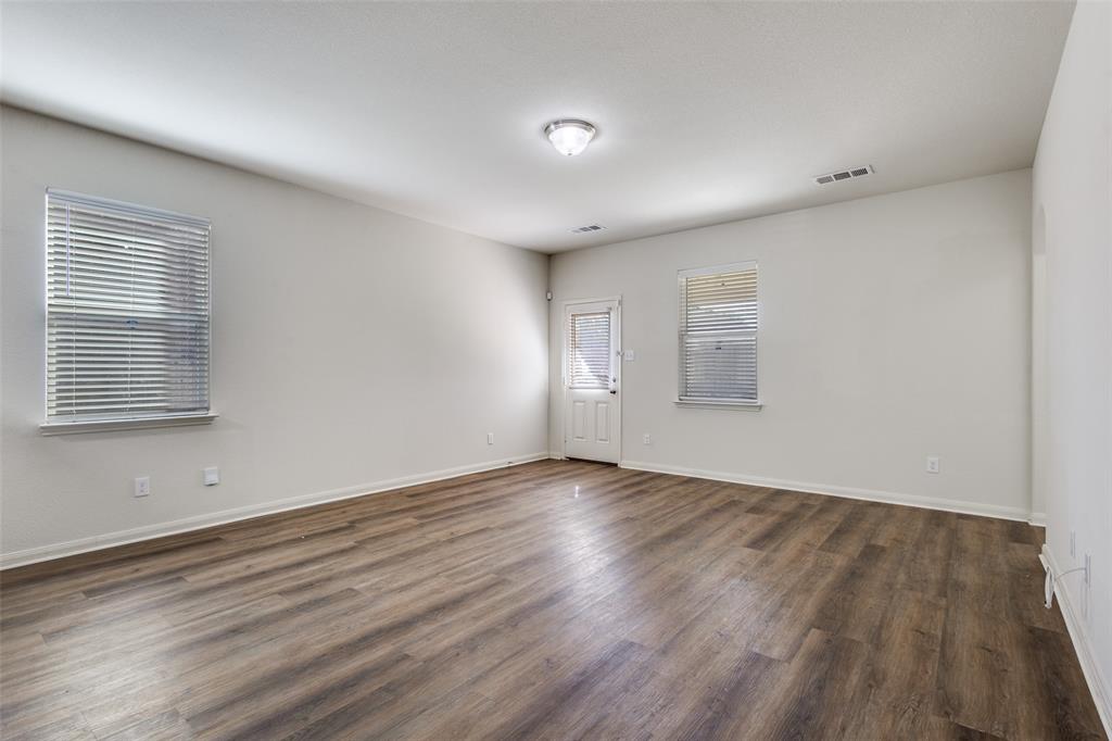 1707 Hot Springs Way Princeton, TX 75407 - Photo 5 of 12 an empty room with wooden floor and windows