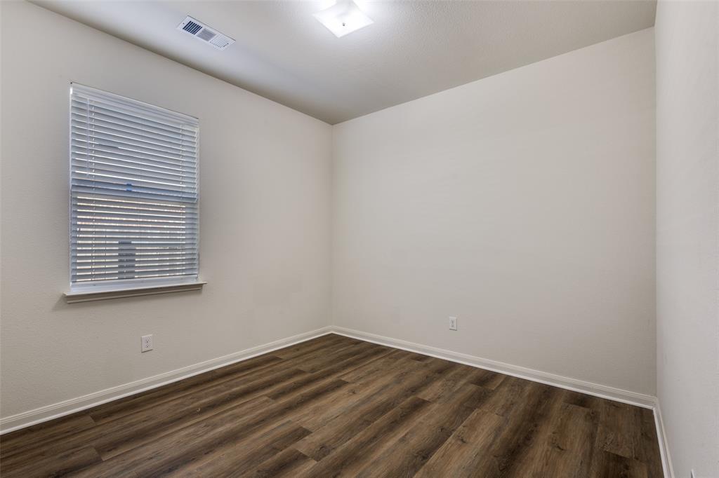 1707 Hot Springs Way Princeton, TX 75407 - Photo 9 of 12 a view of an empty room with wooden floor and a window