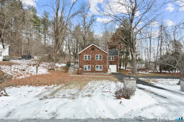 a front view of a house with a yard covered in snow