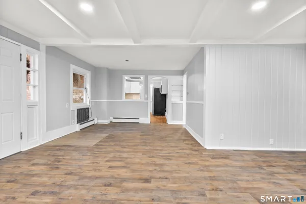 a view of empty room with wooden floor