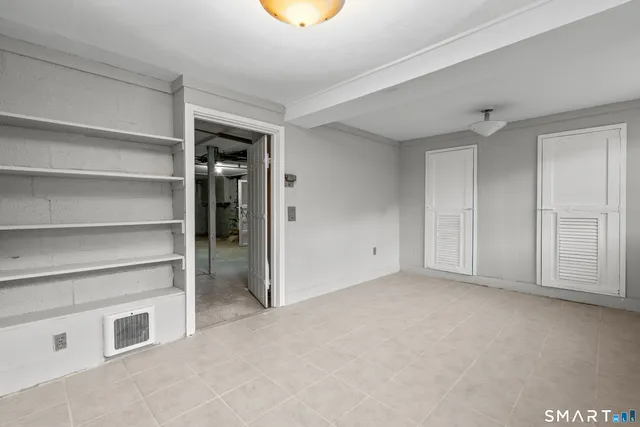 a view of an empty room with a cabinet and a window