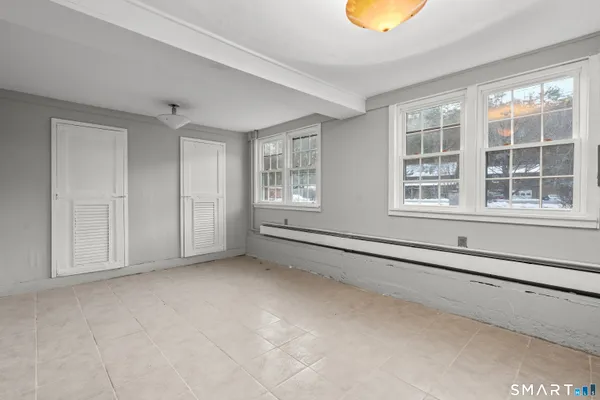 a view of an empty room with a cabinet and a window
