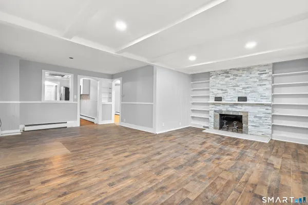 a view of an empty room with a fireplace and a window