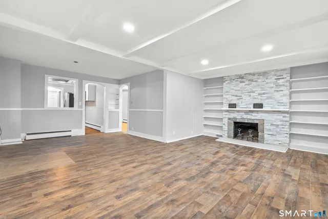 a view of an empty room with a fireplace and a window