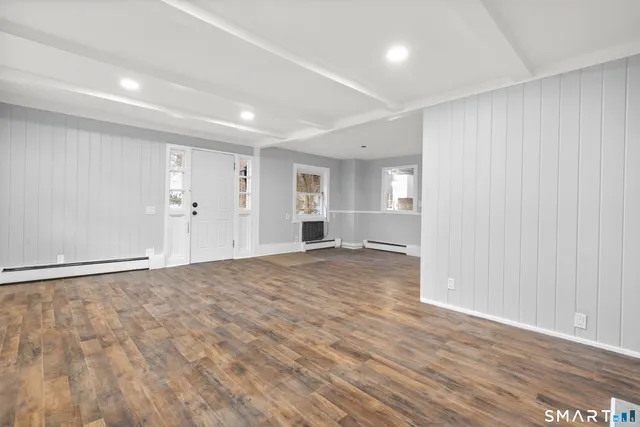 a view of empty room with wooden floor