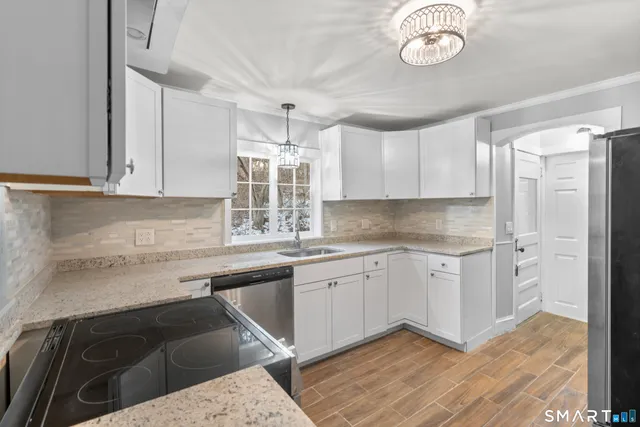 a kitchen with stainless steel appliances granite countertop a sink and cabinets
