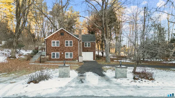 a front view of a house with a yard covered in snow