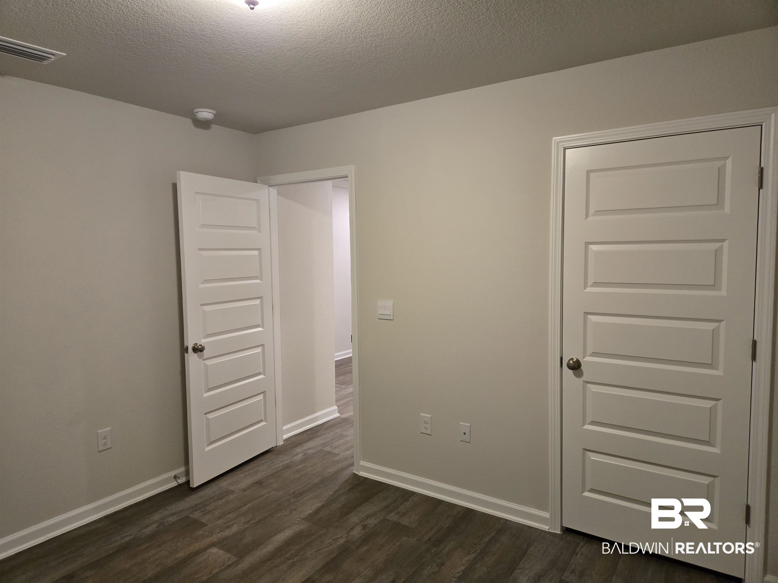24194 Veranda Circle Elberta, AL 36530 - Photo 9 of 31 Unfurnished bedroom with dark hardwood / wood-style flooring and a textured ceiling