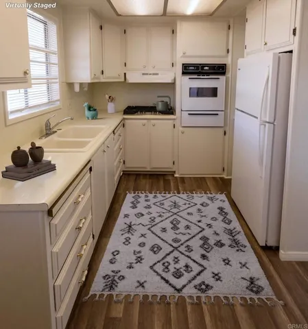 a kitchen with a sink a stove a refrigerator and a window