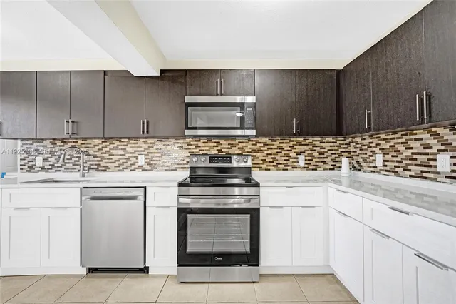 a kitchen with white cabinets and white appliances