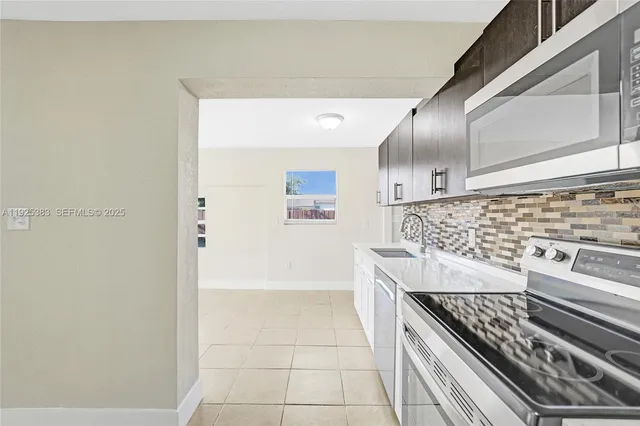 a kitchen with granite countertop a sink and white stainless steel appliances