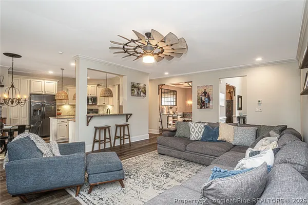 a living room with furniture kitchen view and a chandelier