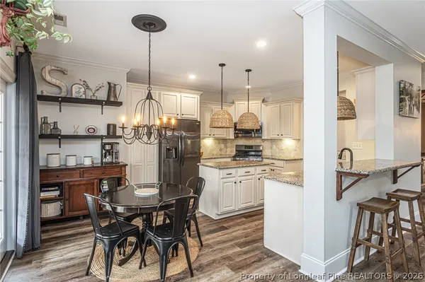 a kitchen with refrigerator and chairs