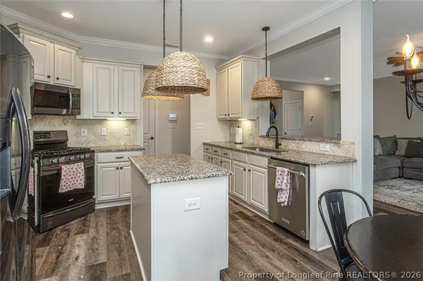 a kitchen with kitchen island granite countertop a stove oven and a sink