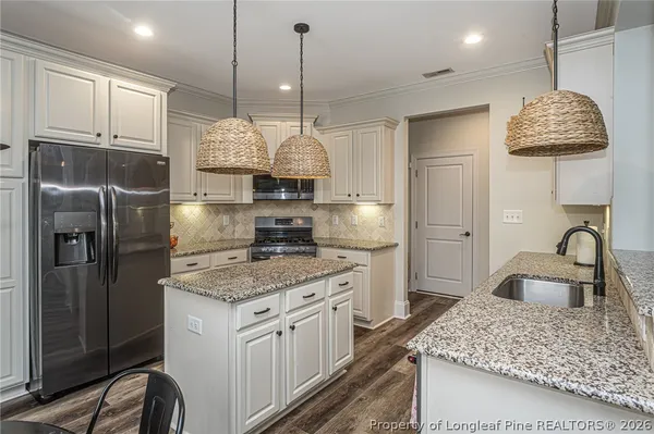 a kitchen with stainless steel appliances granite countertop a sink a stove and a refrigerator