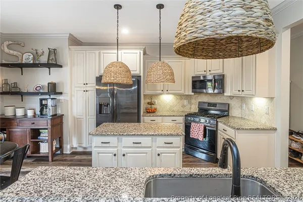 a kitchen with stainless steel appliances granite countertop a stove a sink and a refrigerator