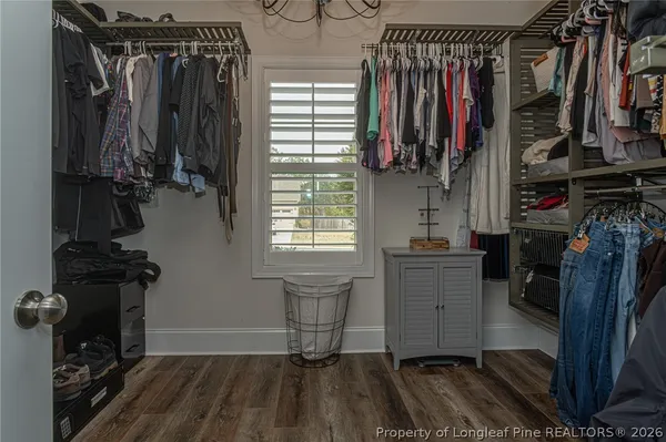 a view of walk in closet with clothes and shoes