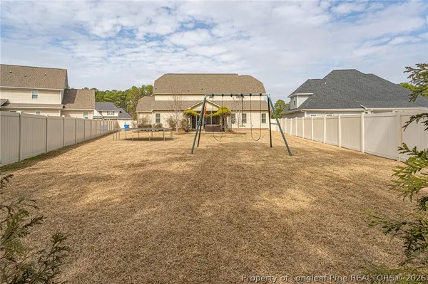 a view of swimming pool with a yard and fence