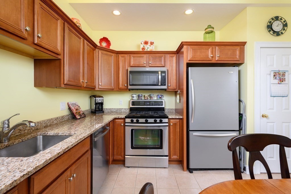 25 Hemlock Circle, Unit 25 Hanover, MA 02339 - Photo 6 of 36 a kitchen with granite countertop a stove and a refrigerator