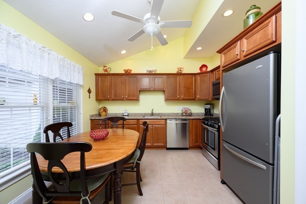 25 Hemlock Circle, Unit 25 Hanover, MA 02339 - Photo 7 of 36 a kitchen with granite countertop a table chairs a refrigerator and a sink