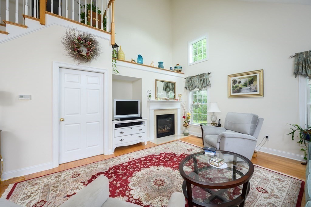 25 Hemlock Circle, Unit 25 Hanover, MA 02339 - Photo 9 of 36 a living room with furniture a fireplace and flat screen tv