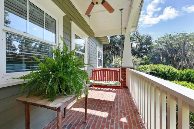 a living room with furniture a rug a lamp and a large window
