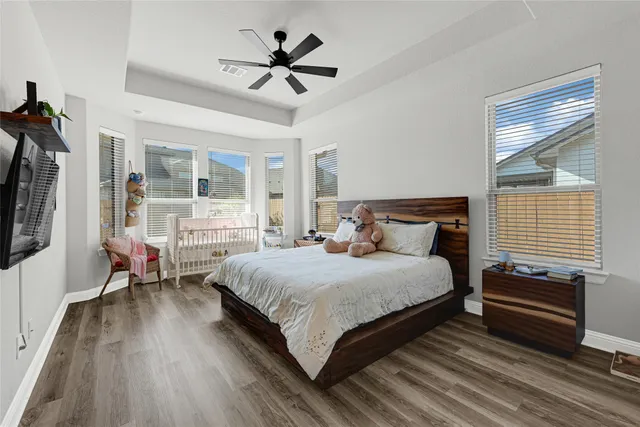 a bedroom with a bed a chandelier and a window