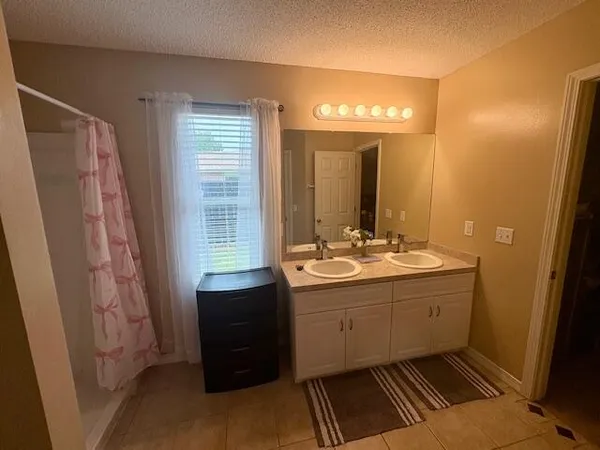 a bathroom with a double vanity sink and a mirror