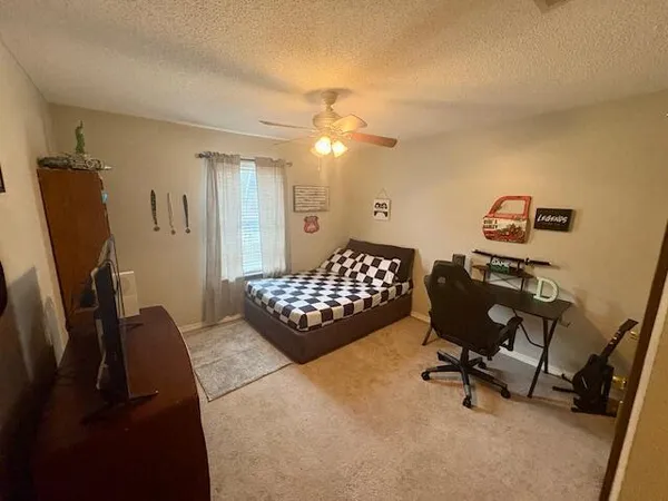 a bedroom with a bed dresser and a desk